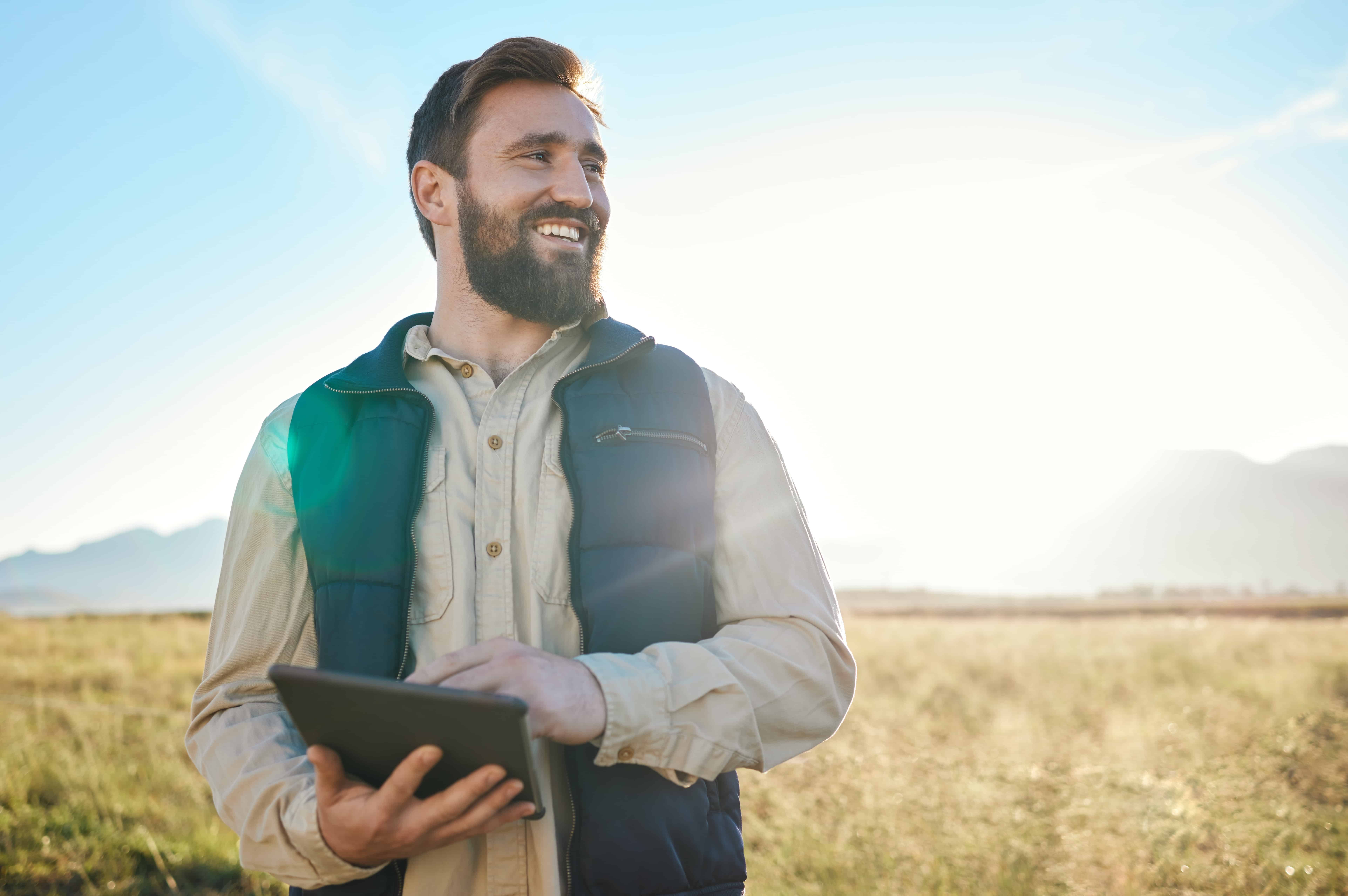 Research or agriculture man on tablet on farm for sustainability, production or industry growth analysis. Agro, happy or farmer on countryside field for weather, checklist or data search in Texas AdobeStock 569839996 Utilities